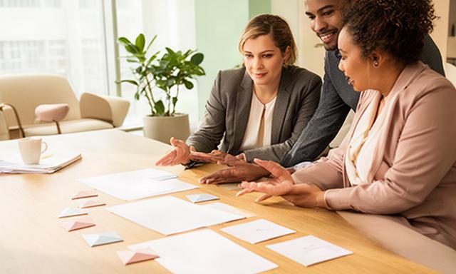 Consultants bespreken een groeiplan aan een houten tafel in een lichte vergaderruimte